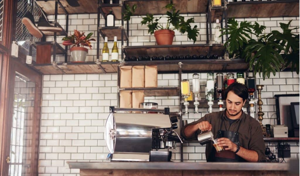 Barista making a coffee drink inside cafe