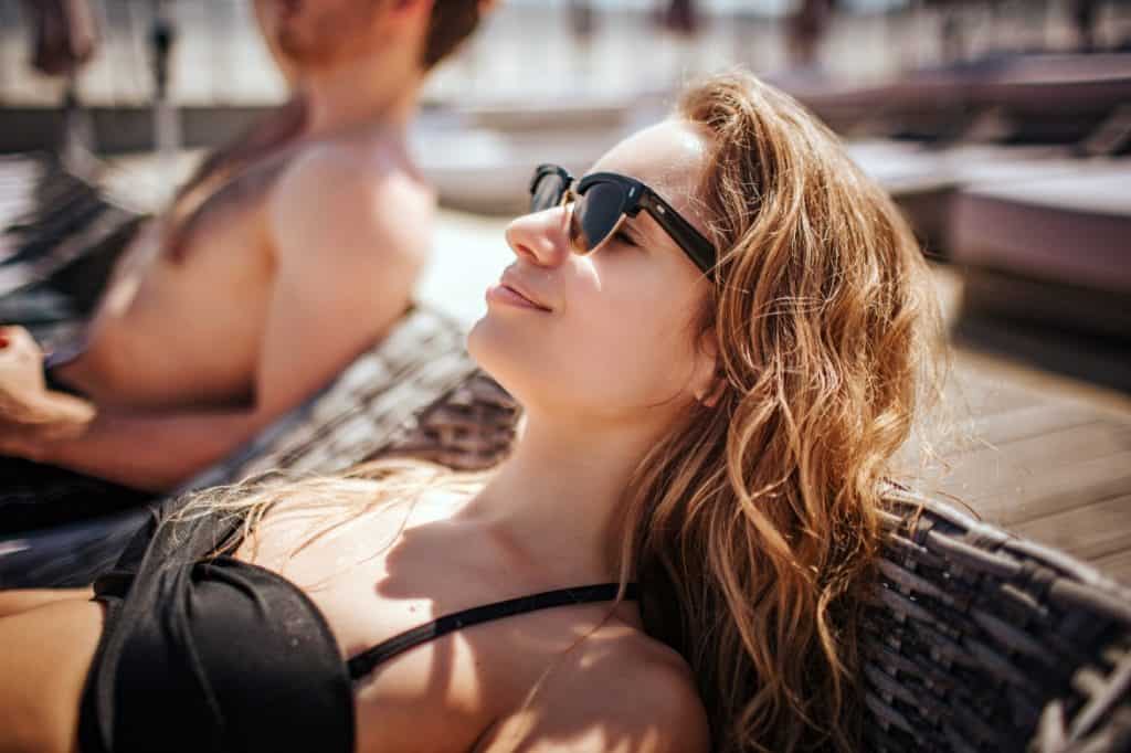 Young woman lounging by pool