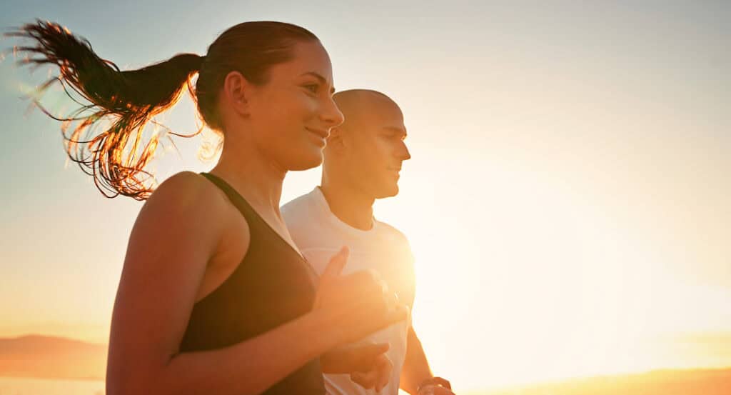 Young man and woman on a jog at sunrise